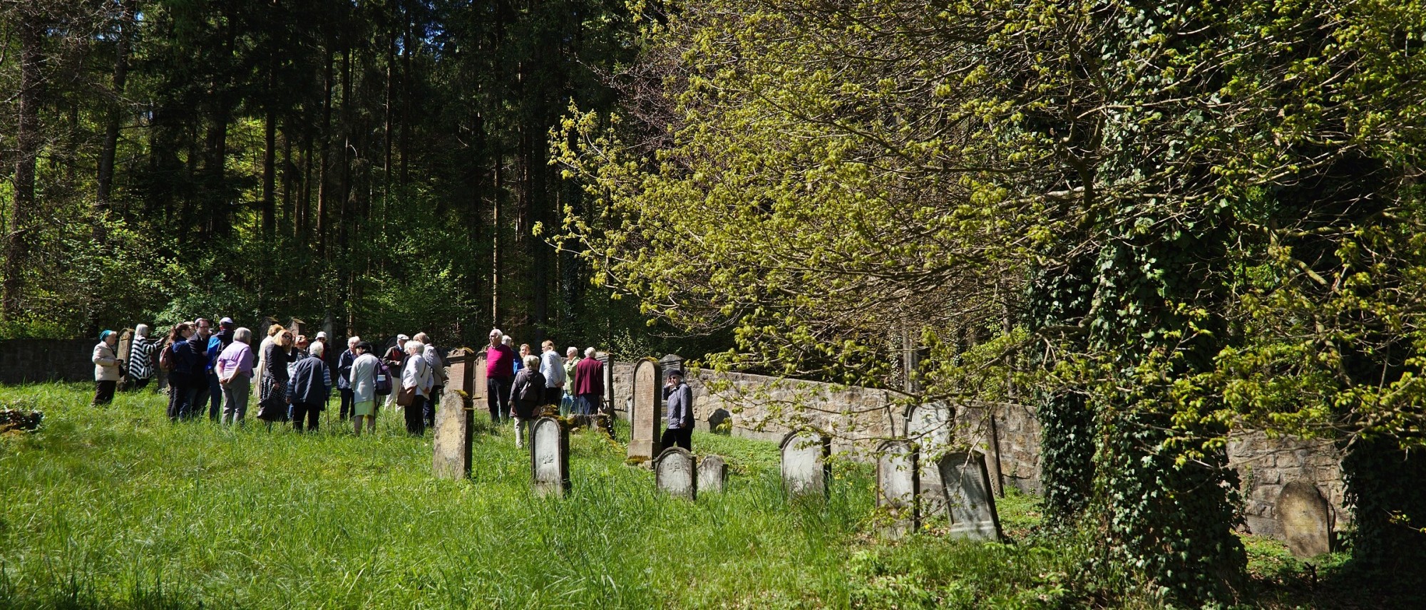 Eine Gruppe Menschen auf dem Friedhof in Osterberg.